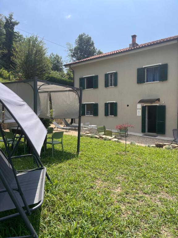Giardino privato con pergola, sedie verdi e vista colline